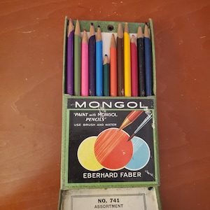 May include: A box of 12 watercolor pencils labeled "MONGOL "PAINT with MONGOL PENCILS" USE BRUSH AND WATER" EBERHARD FABER NO. 741 ASSORTMENT. The box is green with a white label and a picture of three colored circles.
