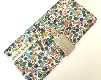 May include: A white fabric pouch with a floral pattern in shades of blue, green, and orange. The pouch has a brown button and a beige fabric flap with the text "Livret de famille" printed on it.