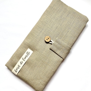 May include: A beige linen pouch with a wooden button closure and a white label that says "Livret de famille".
