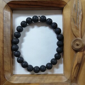 Peut inclure: Un bracelet en perles de roche volcanique noire avec un fermoir en métal argenté.