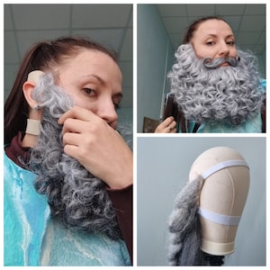 Peut inclure: Un ensemble barbe et moustache bouclée grises. La barbe est fixée à un cache-oreille beige et à un élastique blanc. La moustache est une pièce séparée. La barbe et la moustache sont conçues pour ressembler à une barbe de Père Noël.