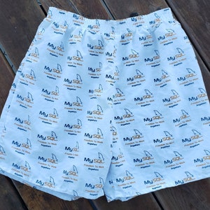 May include: White men's swimming trunks with a blue and gold pattern. The pattern features the text "My SQL Freedom To Work Anywhere".