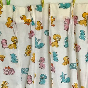 May include: White curtains with a repeating pattern of colourful cartoon animals, including ducks, bunnies, and kittens.