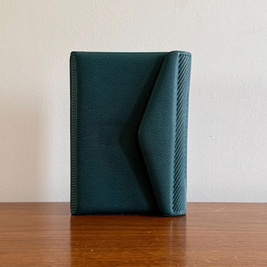 May include: A dark green leather wallet with a textured flap.