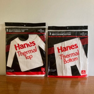 Peut inclure: Deux paquets de sous-v&ecirc;tements thermiques blancs, un haut et un bas, tous deux &eacute;tiquet&eacute;s "Hanes Thermal" en lettres rouges. Les paquets sont tous deux de taille moyenne et sont faits de 65% de coton et 35% de polyester.