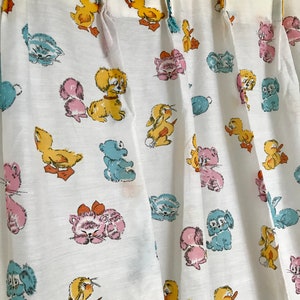 May include: White fabric curtains with a repeating pattern of cartoon animals, including ducks, kittens, puppies, and bunnies. The animals are in shades of yellow, pink, blue, and brown.