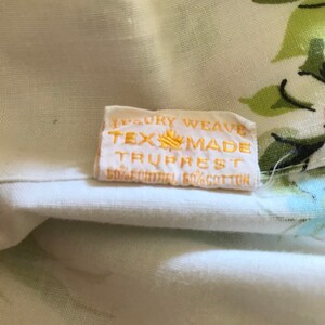 Puede incluir: Una tela blanca con un patr&oacute;n floral y una etiqueta amarilla que dice "Luxury Weave Tex-Made Truprest 50%  Contrel 50% Cotton".