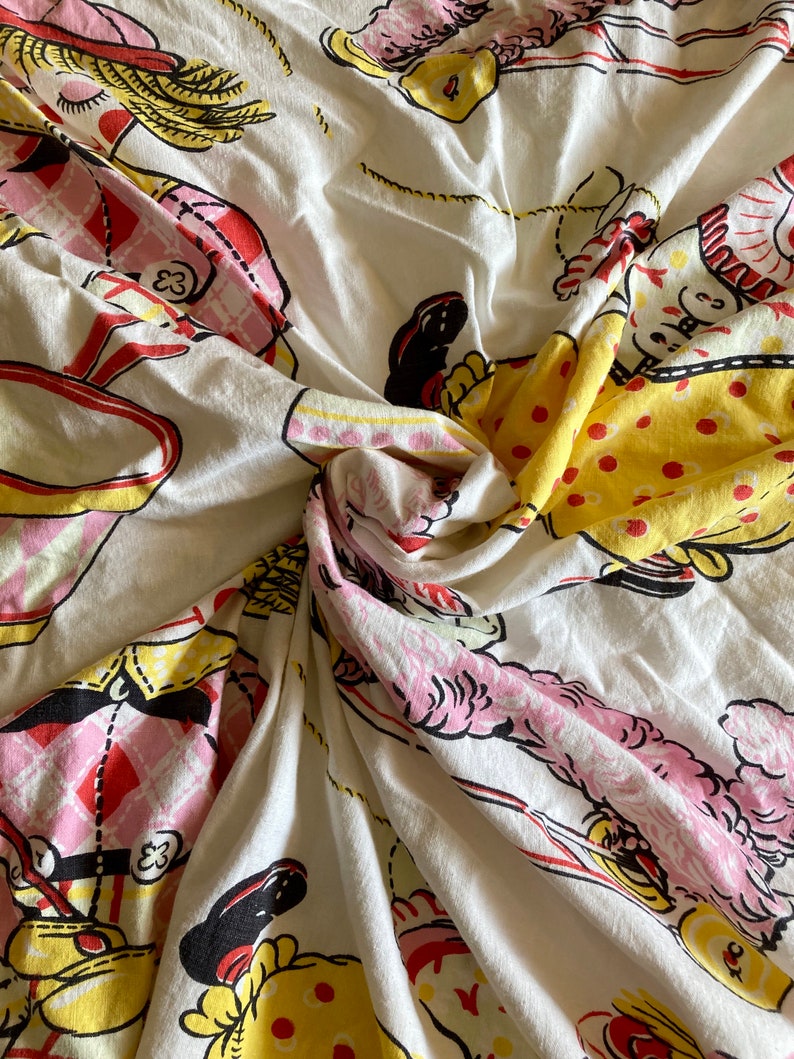 May include: White fabric with a repeating pattern of clowns in pink, yellow, and red. The clowns are wearing hats and holding various objects. The fabric is crumpled and folded.