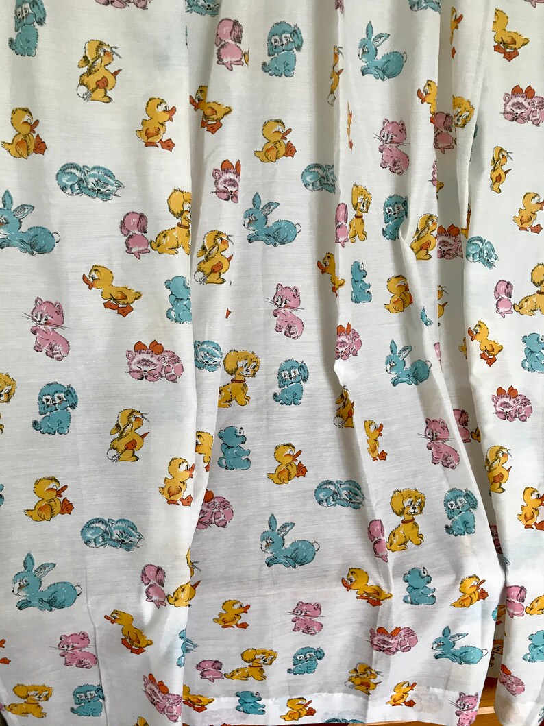 May include: White fabric with a repeating pattern of cartoon animals. The animals include ducks, bunnies, cats, and dogs in various colors, including pink, blue, yellow, and orange.