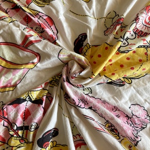May include: White fabric with a repeating pattern of clowns in various poses. The clowns are wearing colorful clothing with polka dots and plaid patterns. The fabric is wrinkled and has a vintage feel.