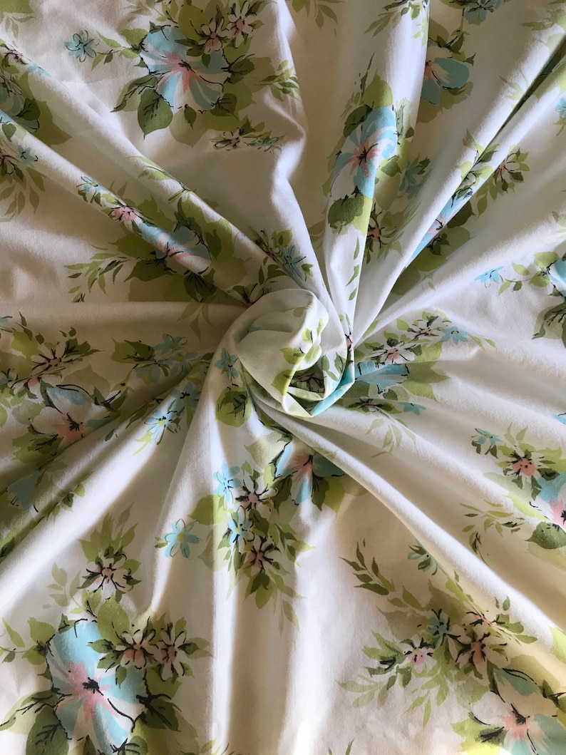 Puede incluir: Tela blanca con un patr&oacute;n floral con flores azules y rosas y hojas verdes.
