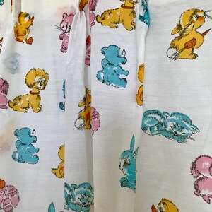 May include: White fabric with a repeating pattern of cartoon animals, including a duck, cat, dog, bear, rabbit, and bunny. The animals are in various colors, including yellow, blue, pink, and brown.