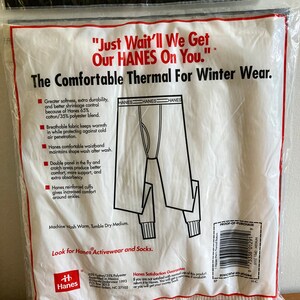 Peut inclure: Emballage de sous-v&ecirc;tements thermiques blancs avec une bordure rouge et noire. L'emballage pr&eacute;sente un sous-v&ecirc;tement thermique blanc avec le texte "Just Wait'll We Get Our HANES On You." et "The Comfortable Thermal For Winter Wear."