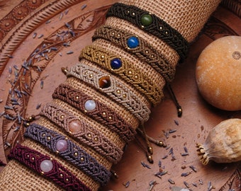 May include: A collection of eight handmade friendship bracelets with different colored cords and gemstone beads. The bracelets are arranged on a brown burlap background.