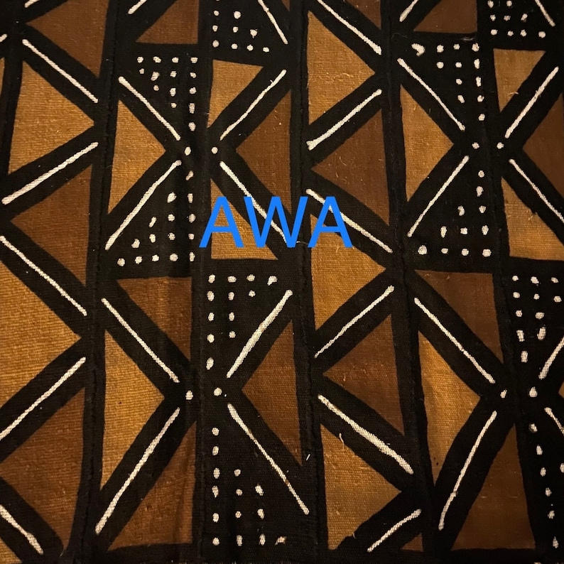 May include: A black and brown fabric with a geometric pattern of triangles and white lines. The fabric has the word "AWA" printed in blue letters in the center.