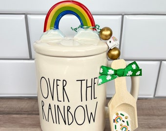 Peut inclure: Une tasse en céramique blanche avec un couvercle arc-en-ciel et une cuillère en bois. La tasse dit "Over the Rainbow".