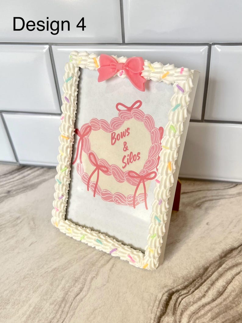 May include: White picture frame with a pink bow and sprinkles around the edge. The frame has a pink heart with the text "Bows & Silos" inside.