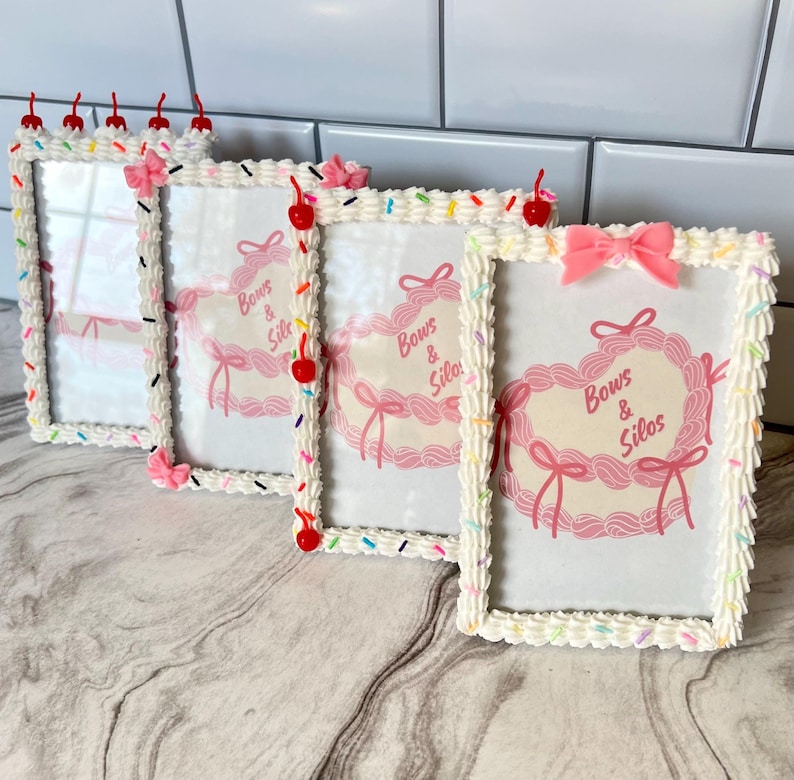 May include: Four white picture frames with a frosting-like design and colorful sprinkles. Each frame has a pink bow and the text "Bows & Silos" in pink.