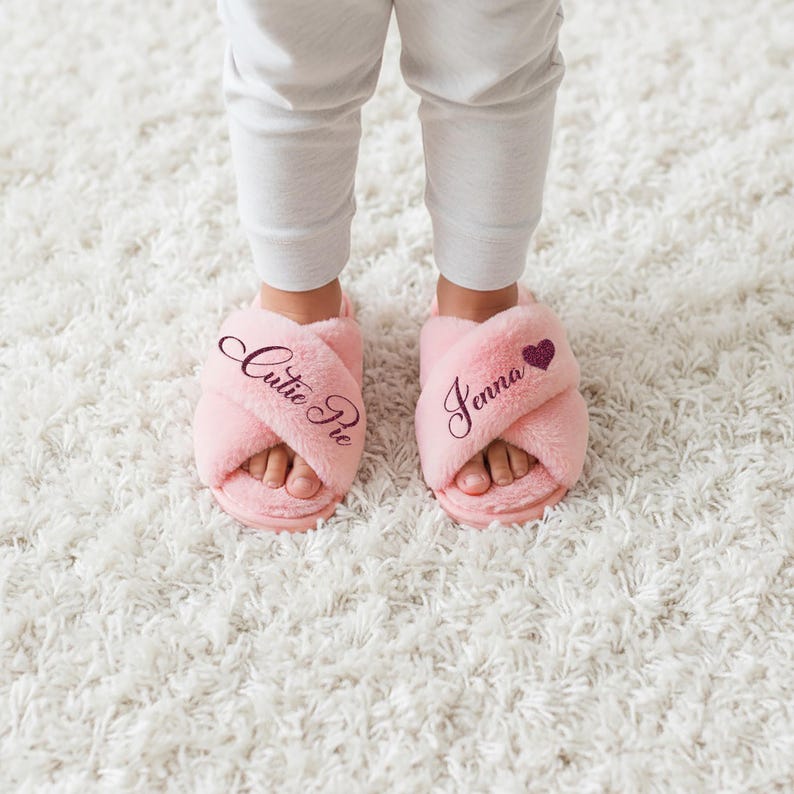 Toddler slippers that can be customized with any text and a select list of symbols.  These fuzzy slippers are available for 3T to Big Kid 3Y. They feature an anti-slip sole.