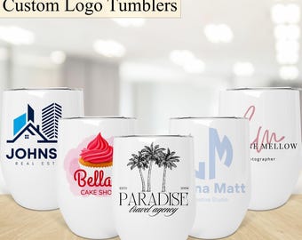Pode incluir: Cinco copos de aço inoxidável brancos com diferentes logotipos impressos neles. Os logotipos incluem uma empresa imobiliária, uma pastelaria, uma agência de viagens, um estúdio criativo e um fotógrafo.