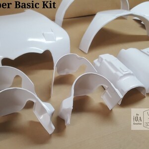 May include: A white plastic kit for building a Supertrooper costume. The kit includes various pieces, including a helmet, chest piece, and shoulder pads.