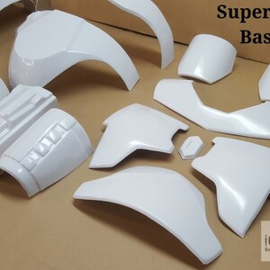May include: A white plastic kit for making a Supertrooper costume. The kit includes pieces for the chest, shoulders, arms, and legs.
