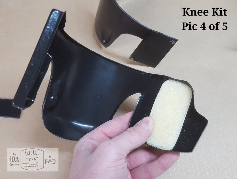 May include: Close-up of a black knee pad with a foam insert. The knee pad is designed to protect the knee from impact and abrasion. The foam insert is designed to provide cushioning and comfort. The knee pad is part of a knee kit.