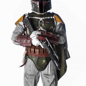 Pode incluir: Um traje de Boba Fett de Star Wars verde, marrom e cinza com um rifle blaster. O traje inclui um capacete com um tel&ecirc;metro, uma placa de peito, um cinto com bolsas e joelheiras.