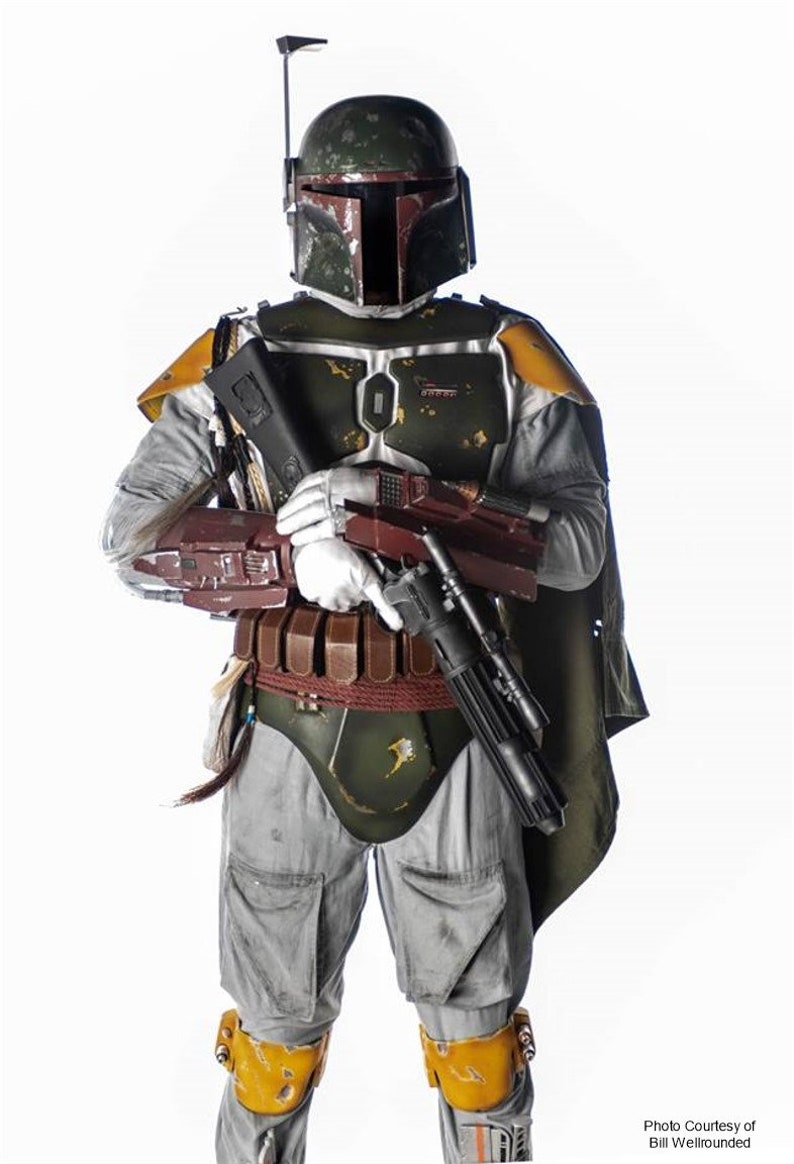 Pode incluir: Um traje de Boba Fett de Star Wars verde, marrom e cinza com um rifle blaster. O traje inclui um capacete com um tel&ecirc;metro, uma placa de peito, um cinto com bolsas e joelheiras.