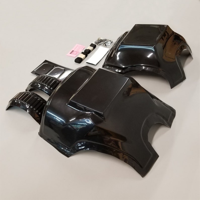 Puede incluir: Un conjunto de piezas de carrocer&iacute;a de coche de pl&aacute;stico negro para un coche modelo. El conjunto incluye un techo, dos paneles laterales y dos pasos de rueda.