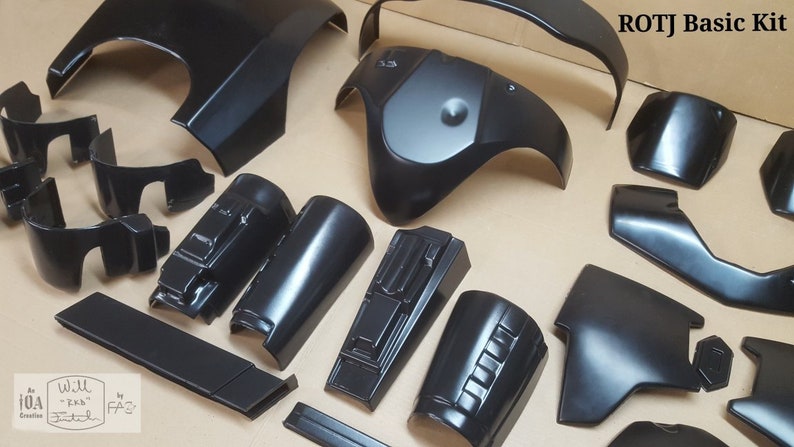 Pode incluir: Um conjunto de pe&ccedil;as de pl&aacute;stico preto para um fato, etiquetado como "ROTJ Basic Kit".