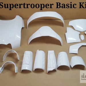May include: A white plastic kit for building a Supertrooper costume. The kit includes pieces for the chest, back, arms, legs, and head. The pieces are all unpainted and ready to be assembled.