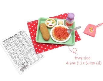 May include: Miniature food set on a green tray, including spaghetti, a corn dog, and a small salad. A pink bag with a duck graphic and a calendar are also present. The tray measures 4.7cm long and 3.7cm high.