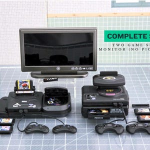 May include: A complete set of miniature retro gaming consoles, including two game sets, a monitor, controllers, and game cartridges. The set features a black color scheme and includes the text "COMPLETE SET".