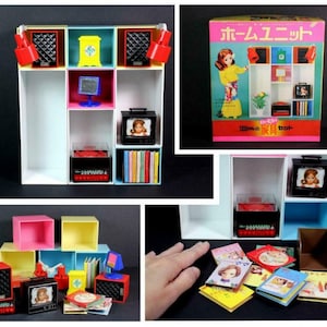 May include: A miniature dollhouse furniture set featuring a white shelf unit with various compartments. The set includes a small television, radio, speakers, books, and decorative items. The color palette includes red, yellow, blue, and pink.