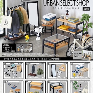 Puede incluir: Un conjunto de ocho figuras en miniatura que representan una tienda de ropa urbana con temática de Peanuts. El conjunto incluye un perchero, un espejo, una caja registradora, una bicicleta y varios otros accesorios. Las figuras son de plástico y miden aproximadamente 5 cm de alto. El conjunto está empaquetado en una caja con una ventana que permite ver las figuras en el interior.