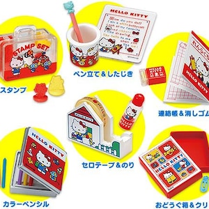Puede incluir: Una colección de artículos de papelería de Hello Kitty, que incluye un juego de sellos, un portalápices, un bloc de notas, una goma de borrar, un dispensador de cinta adhesiva, una barra de pegamento, lápices de colores y una caja con clips. Los artículos son rojos, blancos y amarillos.