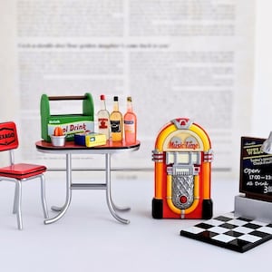 May include: A miniature diner scene featuring a red chair, a table with drinks, a jukebox, and a sign. The jukebox is orange and red with "Music Time" on it. The sign has a checkerboard base. The table is 60 cm in diameter.