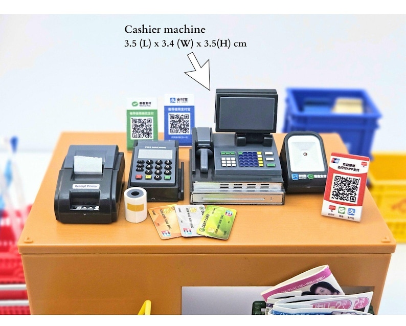May include: Miniature cashier machine set with a receipt printer, payment terminal, and scanner. Includes credit cards and QR code signs. The cashier machine measures 3.5 cm (L) x 3.4 cm (W) x 3.5 cm (H).