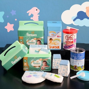 以下が含まれることがあります： おむつ、粉ミルク、おしりふきなど、ベビーケア用品が並んでいます。画像には、パンパースのおむつの箱、粉ミルクの缶、ベビーフードの容器が写っています。背景には、漫画の赤ちゃんとうさぎがいます。