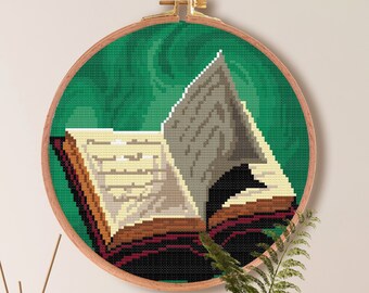May include: A cross-stitch pattern of an open book with a green background. The pattern is in a round embroidery hoop and is 7.1 inches by 7.1 inches. The pattern is for Aida cloth with 14 count and requires 15 DMC colors.