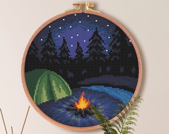 May include: Cross stitch pattern of a camping scene with a tent, campfire, and trees under a starry night sky. The pattern is in a round embroidery hoop, with a size of 7.1 inches by 7.1 inches, or 18.1 centimeters by 18.1 centimeters. The pattern requires 100 stitches by 100 stitches and uses 21 DMC colors.