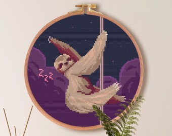 May include: Cross stitch pattern of a sloth hanging from a pole in a purple and blue starry sky. The pattern is 100 stitches by 100 stitches and measures 7.1 inches by 7.1 inches or 18.1 cm by 18.1 cm. The pattern uses 14 DMC colors.