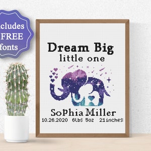 May include: A cross-stitch pattern featuring a purple and blue galaxy elephant with a baby elephant inside. The text "Dream Big little one" is above the elephant and the text "Sophia Miller 10.26.2020 6lbs 5oz 21 inches" is below the elephant.