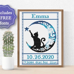 Puede incluir: Un patrón de punto de cruz con un gato negro alcanzando una estrella en una luna creciente azul y blanca. El patrón incluye el nombre "Emma", la fecha "10.26.2020" y la hora "7:30AM 8lbs. 5oz 21in".
