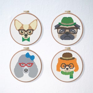 May include: Four cross-stitch embroidery hoops with different dog breeds wearing glasses and hats. The dogs are a chihuahua, a pug, a poodle, and a fox.