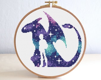 May include: A cross-stitch embroidery hoop with a purple, blue, and green galaxy dragon design. The dragon is outlined in black and has white stars throughout.