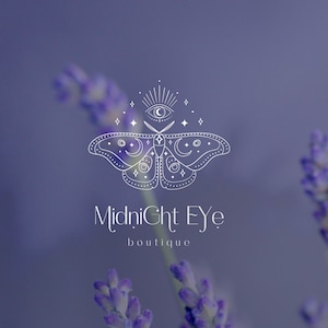 May include: A white line drawing of a moth with a crescent moon and a star on each wing. The moth has an eye with a starburst above it. The text "Midnight Eye boutique" is below the moth.