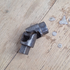 Könnte beinhalten: Ein silberner Universalgelenksockelschlüssel mit einem 3/8 Zoll Antrieb.