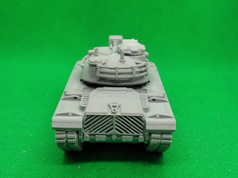 May include: A gray plastic model of a tank with a detailed turret and a grill-like front.